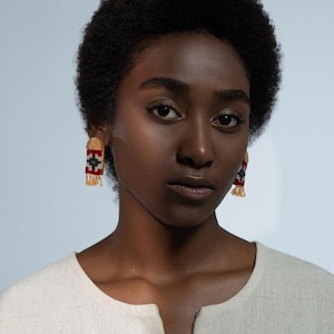 Model wearing LaLan's Saffron Dome Kilim Wooden Earrings, featuring a dome-shaped kilim design with warm saffron tones, framed by walnut wood.