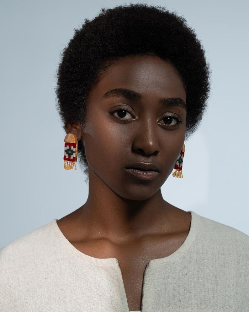 Model wearing LaLan's Saffron Dome Kilim Wooden Earrings, featuring a dome-shaped kilim design with warm saffron tones, framed by walnut wood.