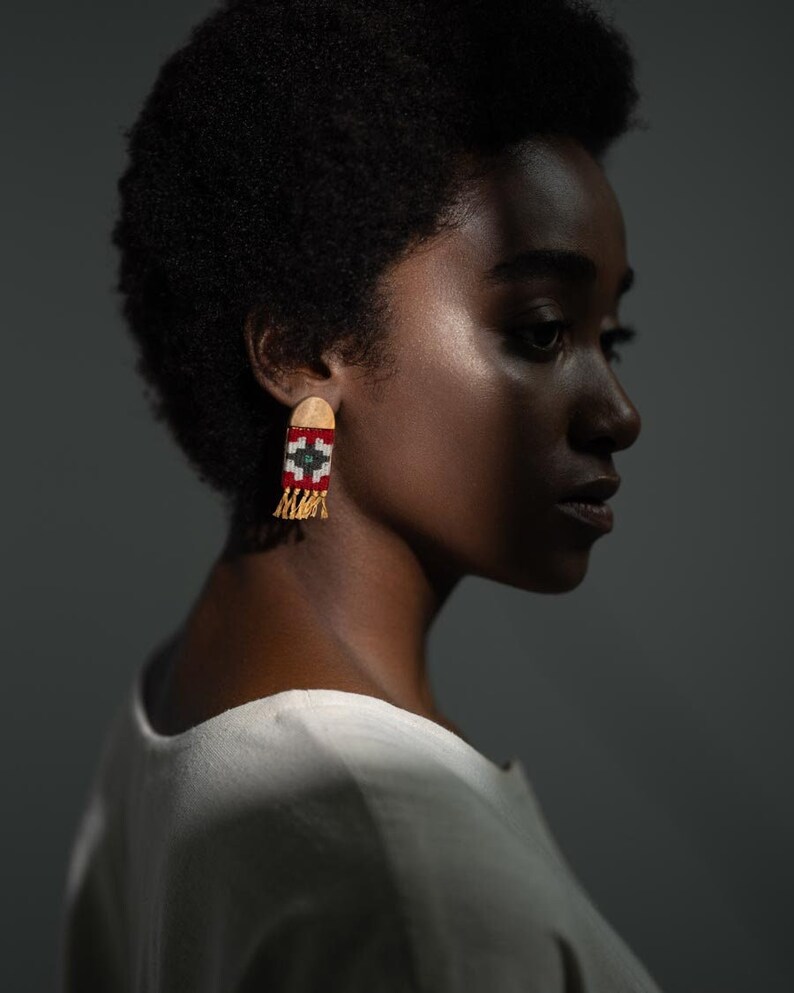 Model wearing LaLan's Saffron Dome Kilim Wooden Earrings, featuring a dome-shaped kilim design with warm saffron tones, framed by walnut wood.