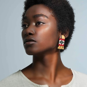 Model wearing LaLan's Saffron Dome Kilim Wooden Earrings, featuring a dome-shaped kilim design with warm saffron tones, framed by walnut wood.
