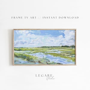 Puede incluir: Una pintura digital de un paisaje costero con un faro en la distancia. La pintura presenta un cielo azul con nubes blancas, hierbas de marisma verdes y una masa de agua azul. La pintura está enmarcada en un marco de madera claro.