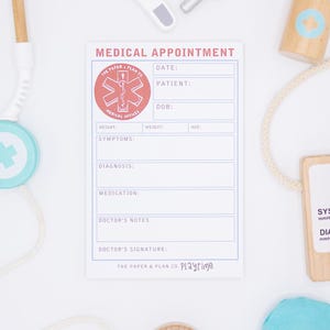 Puede incluir: Un conjunto de juguetes médicos de madera, que incluye un estetoscopio, un termómetro, una jeringa, un frasco de medicina y un monitor de presión arterial. También se incluye un formulario de cita médica. Los juguetes son blancos, azules y de tonos de madera natural.