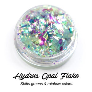 May include: A small jar of iridescent green and purple opal flake. The flake shifts colors in the light. Hydrus Opal Flake. Shifts greens & rainbow colors.