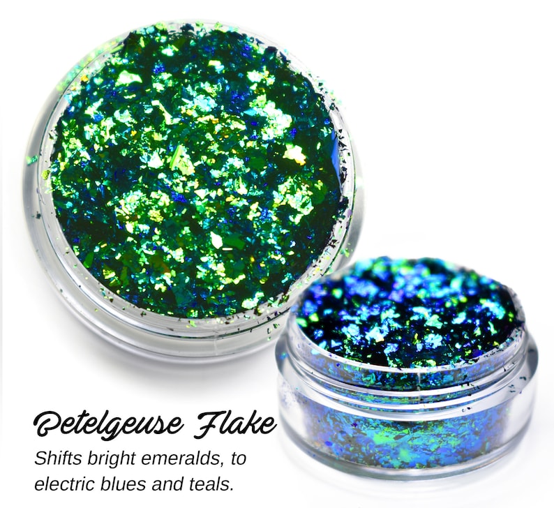 May include: Two jars of iridescent green and blue glitter flakes. The glitter shifts from bright emeralds to electric blues and teals. The label reads "Betelgeuse Flake".