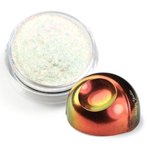 Può includere: Un piccolo barattolo di glitter bianco iridescente con un campione di glitter su una superficie iridescente rosso, arancione e giallo. La superficie è etichettata "Junga Studio."