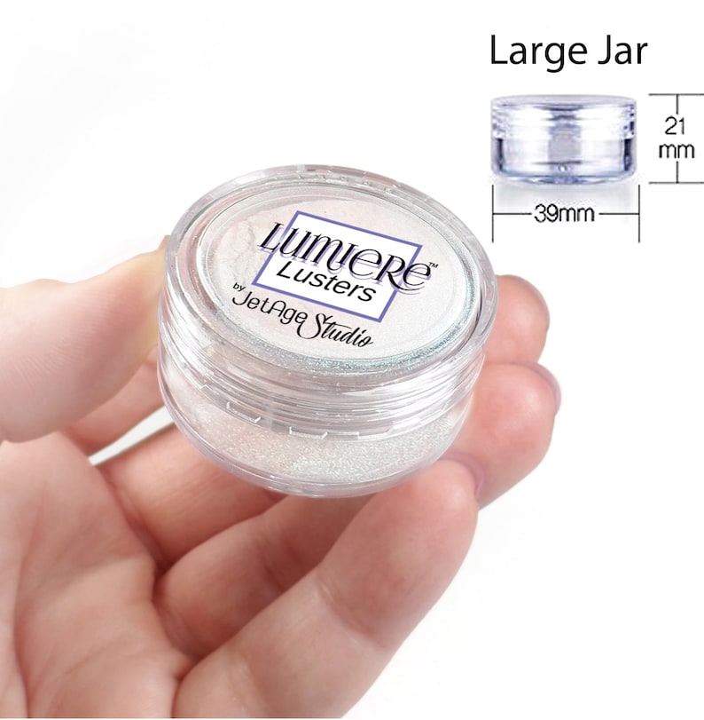 May include: A clear plastic jar filled with white iridescent glitter. The jar is labeled "Lumiere Lusters by JetAge Studio". The jar is 39 mm in diameter and 21 mm in height.