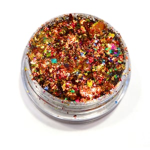 May include: A small round container filled with iridescent gold, red, green, and blue glitter flakes.