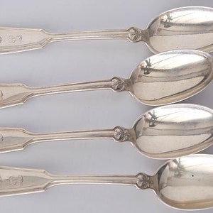 May include: Four silver teaspoons with ornate handles and a shell design. Each spoon has an engraved letter 'S' on the handle.