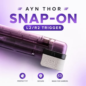 May include: A translucent purple AYN THOR snap-on L2/R2 trigger accessory. The device features a black L1 button and a textured light gray L2 trigger. Text on the image reads AYN THOR SNAP-ON L2/R2 TRIGGER, PERFECT FIT, SECURE, and MADE FOR GAMERS.