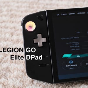 Puede incluir: Un mando negro Legion Go Elite DPad con una pantalla que muestra la configuración y las opciones del mando. El mando tiene una cruceta blanca en forma de cruz y una luz circular. El texto "LEGION GO Elite DPad" es visible.