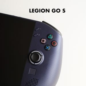 Könnte beinhalten: Eine dunkelblaue tragbare Spielkonsole mit dem Text LEGION GO S darüber. Das Gerät verfügt über einen schwarzen Bildschirm, einen runden Joystick, eine quadratische Taste, ein Lautsprechergitter und vier Aktionstasten mit Dreieck-, Quadrat-, Kreis- und Kreuzsymbolen.