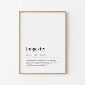 Op de afbeelding: Een ingelijste print met het woord "longevity" in zwarte letters. Daaronder de fonetische uitspraak en de definitie, die de vaardigheid beschrijft om door de ups en downs van het leven te gaan.