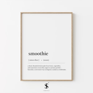 May include: A framed print with the definition of "smoothie" in black text on a white background. The definition includes the pronunciation and a description of the blended drink made from fruits and vegetables. The frame is a light brown color.