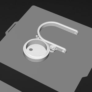A 3D rendering of a metal object with a circular opening, placed on a gray surface.