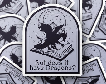 May include: A sticker with a black silhouette of a dragon flying over an open book. The sticker has a white border and a gray background. The text "But does it have Dragons?" is printed in black at the bottom of the sticker.