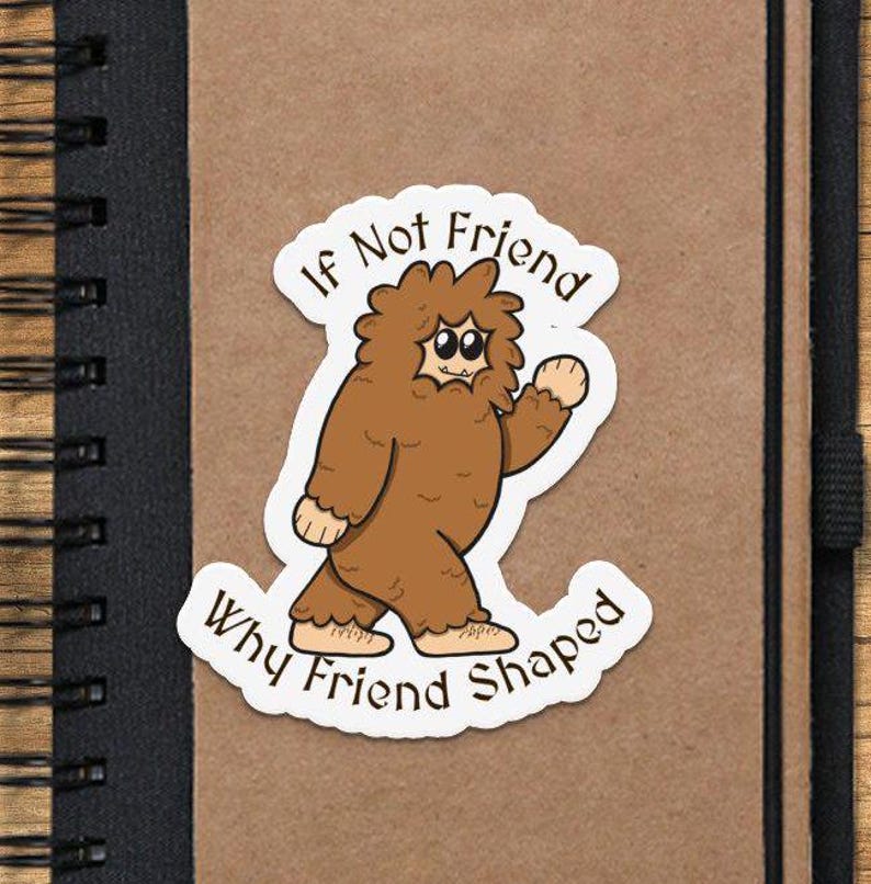 Pu&ograve; includere: Un adesivo con un'illustrazione di un cartone animato di una creatura marrone simile a Bigfoot con il testo "If Not Friend Why Friend Shaped".