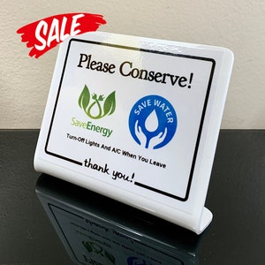 May include: White plastic sign with rounded edges, featuring the text "Please Conserve!" and conservation-themed graphics. The sign includes the phrases "Save Energy" and "Save Water," along with "Turn-Off Lights And A/C When You Leave" and "thank you!" A red "SALE" banner is in the upper left.