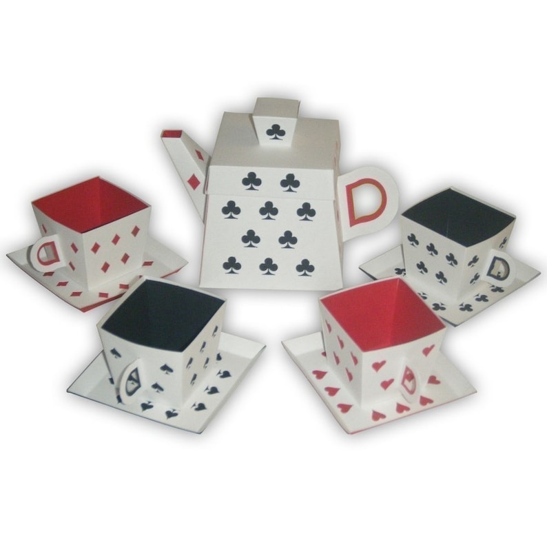 May include: A white tea set with a teapot and four cups and saucers. The teapot and cups are decorated with playing card symbols, including clubs, diamonds, and hearts.