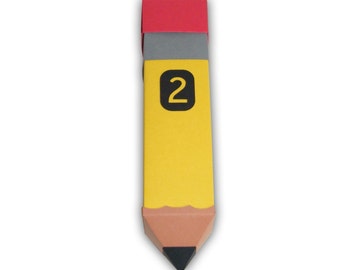 May include: A yellow pencil-shaped bookmark with a black number 2 on the side. The pencil has a brown tip and a red eraser. The bookmark is designed to look like a classic number 2 pencil.