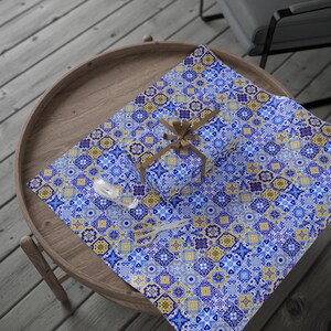 May include: Blue and yellow patterned gift wrap with a small gift box wrapped in the same paper. The gift box is tied with a brown ribbon.