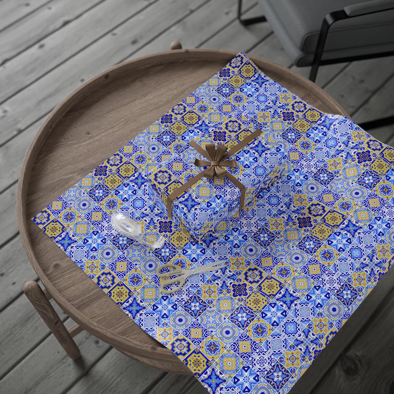 May include: Blue and yellow patterned gift wrap with a small gift box wrapped in the same paper. The gift box is tied with a brown ribbon.
