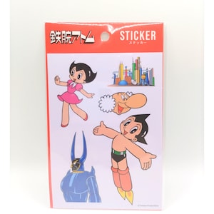 May include: A sticker sheet with cartoon characters. The stickers show a girl in a pink dress, a robot, a man with a large nose, and a blue robot with horns. The top of the sheet has the word "STICKER" in white text.