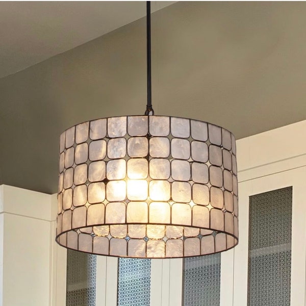 A beautiful and elegant pendant lamp with a black metal frame and a capiz shell shade A perfect addition to any room that needs some natural