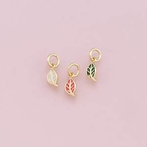 May include: Three gold leaf charms with enamel accents. The leaves are white, red, and green.