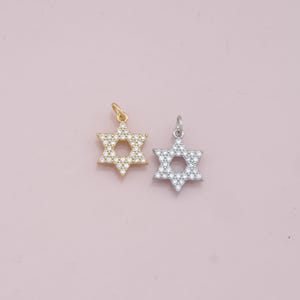 May include: Two silver and gold Star of David charms with clear cubic zirconia stones.