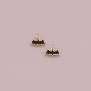 May include: Two gold-colored bat charms with black enamel. The charms are in the shape of a bat with wings spread out.
