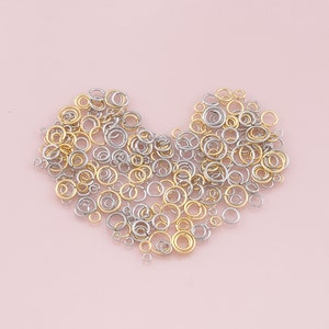 May include: A heart shape made of gold and silver jump rings. The rings are arranged in a random pattern.