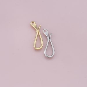 May include: Two metal clasps, one gold and one silver, with a unique curved design. These clasps are perfect for adding a touch of elegance to jewelry or crafts.