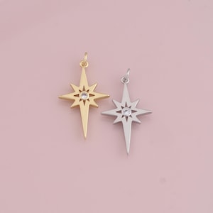 May include: Two star-shaped pendants with a clear rhinestone in the centre. One pendant is gold and the other is silver.