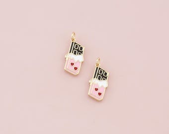 Può includere: Due ciondoli dorati a forma di barrette di cioccolato con glassa rosa e bianca e cuori rossi.