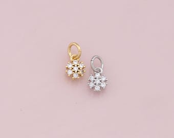 May include: Two small flower charms, one gold and one silver, with clear crystal accents.