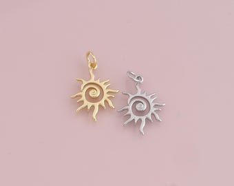 May include: Two sun charm pendants, one gold and one silver, with a spiral design in the center. The charms are on a pink background.