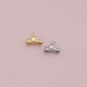 May include: Two small truck charms, one gold and one silver. The charms are detailed with wheels and a cab.