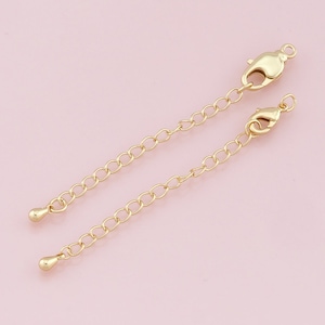May include: Two gold-tone extender chains with lobster claw clasps and small ball ends.