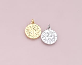 May include: Two sun charm pendants, one gold and one silver, with a detailed sun face design.