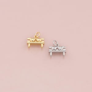 May include: Two gold and silver charm pendants in the shape of a bench with two hearts on top. The charms are perfect for adding a touch of whimsy to jewelry.