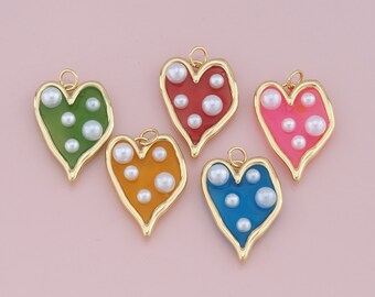 May include: Five gold heart-shaped charms with different colored enamel and white pearl accents. The charms are red, green, yellow, blue, and pink.
