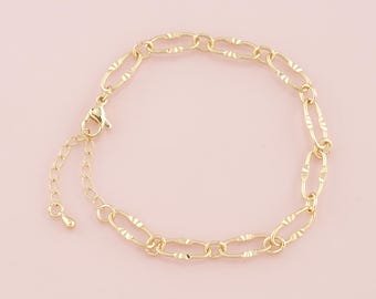 May include: A gold chain bracelet with a textured oval link design. The bracelet has a lobster clasp closure.