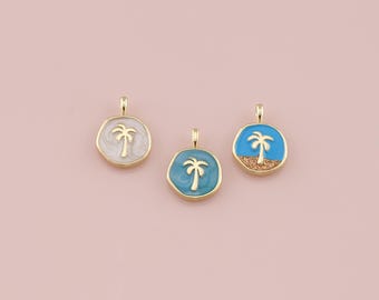 Puede incluir: Tres colgantes dorados con un diseño de palmera. Cada colgante presenta una combinación de colores diferente: blanco con detalles dorados, verde azulado con detalles dorados y azul con un diseño de playa arenosa. Los colgantes son redondos y tienen un pequeño lazo en la parte superior.