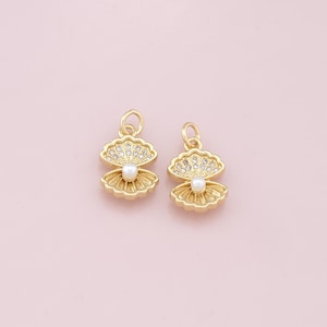 May include: Two gold-tone shell charms with a pearl in the center and clear rhinestones around the edges.