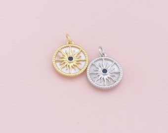May include: Two sun pendant charms, one gold and one silver, with a blue center. The sun has a detailed design with rays.