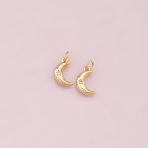 May include: Two gold crescent moon charms with a small clear rhinestone star in the center of each moon.