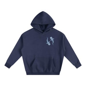 May include: Navy blue hooded sweatshirt with a kangaroo pocket and a drawstring hood. It has a light blue graphic of two whale sharks on the front. The sweatshirt is made of a soft material.