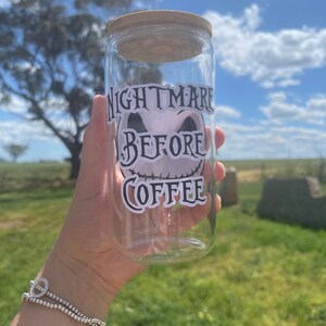 May include: A clear glass jar with a wooden lid and a black and white sticker that says "Nightmare Before Coffee".