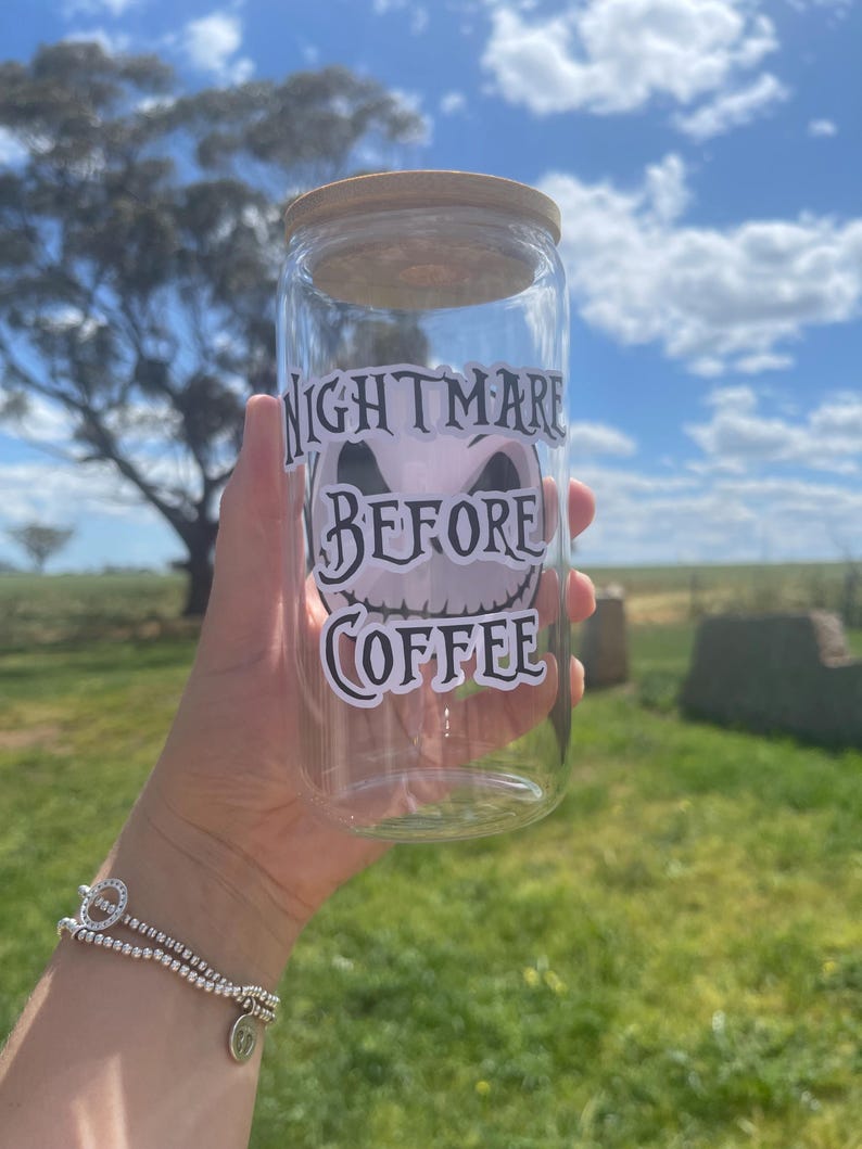 May include: A clear glass jar with a wooden lid and a black and white sticker that says "Nightmare Before Coffee".