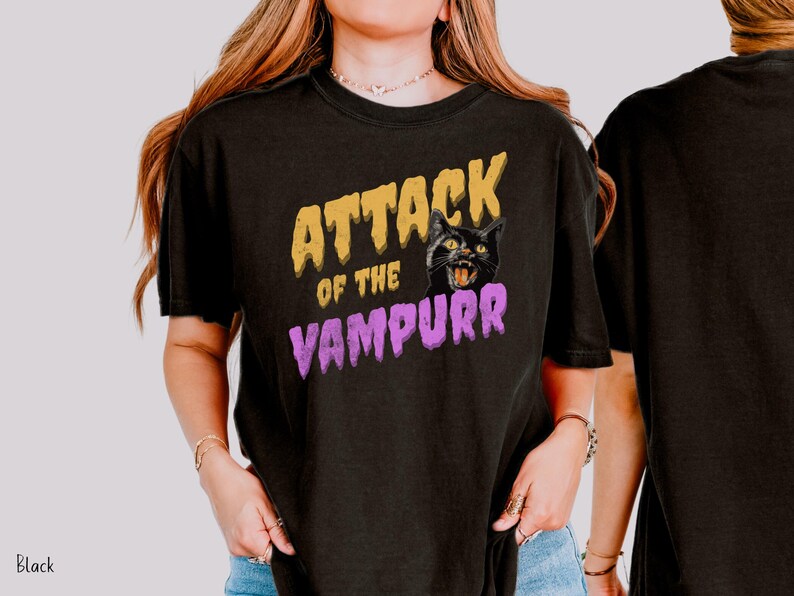 May include: Black t-shirt with a graphic print of a black cat with the text "Attack of the Vampurr" in yellow and purple.